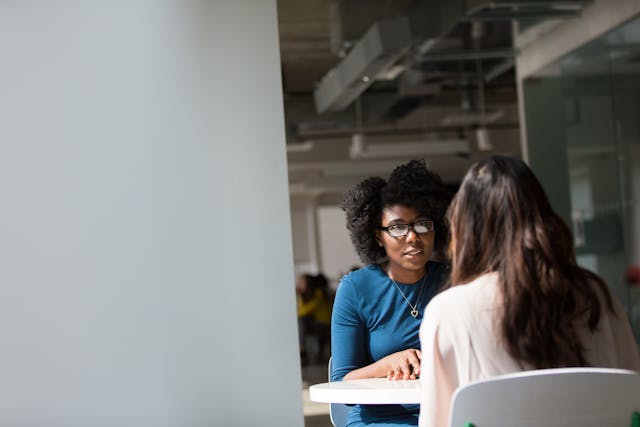 two people speaking at a table