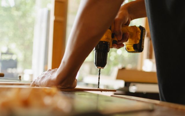 Close-up of a person using a power drill